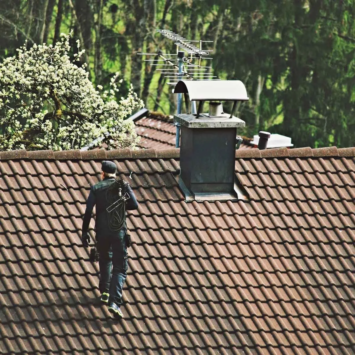 Residential rooftop chimney and cap viewed during an exterior service visit