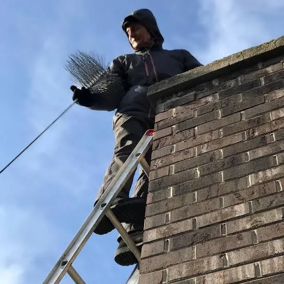 Chimney sweep checking the upper brickwork and crown