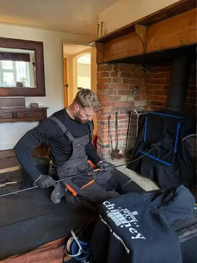Chimney technicians preparing fireplace cleaning equipment indoors